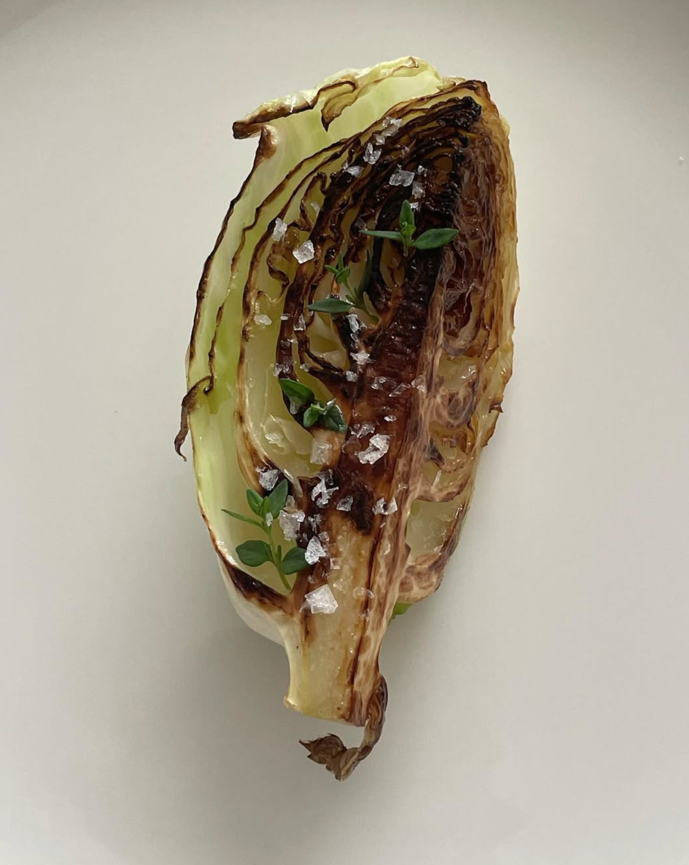 Charred cabbage wedge with herbs and salt